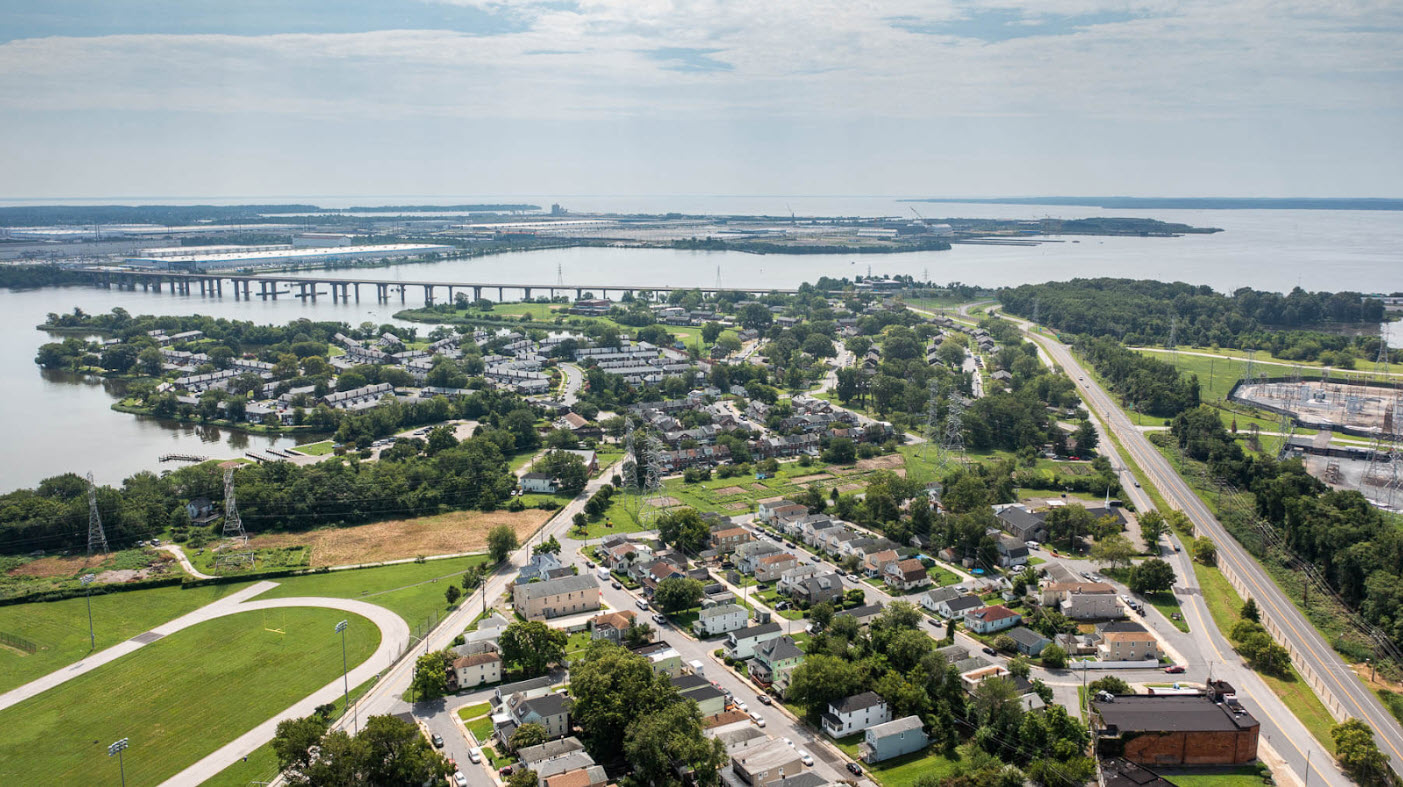 Aerial view of Turner Station, a community in Baltimore County, Maryland. The image shows a mix of residential and industrial areas, with the Chesapeake Bay visible in the background.